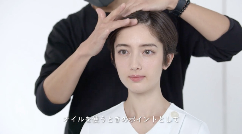 ヘアオイルで髪を整える女性