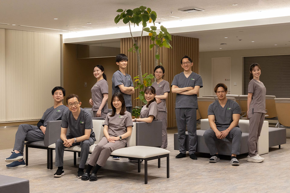 大阪医科薬科大学 形成外科の医局メンバーが着用する、男性はグレー・女性はチャコールグレーのスクラブのユニフォーム