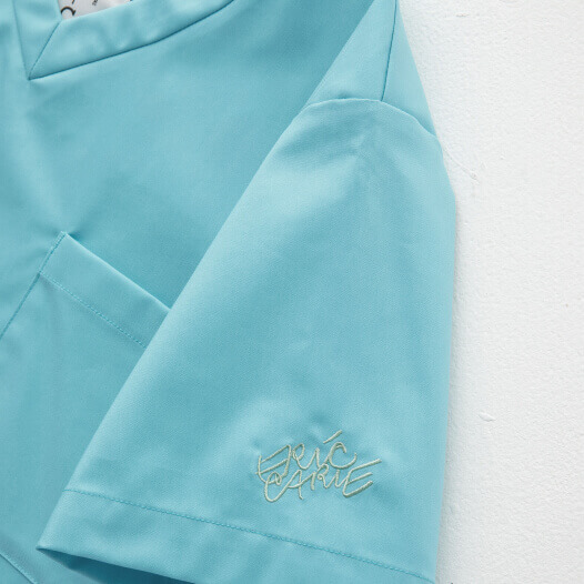 人気の絵本『はらぺこあおむし』と医療ウェアブランド「クラシコ」がコラボレーションしたスクラブ白衣(アクア：水色)のトップス袖のエリック・カールのサイン刺繍